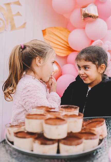 Ragazze davanti a un vassoio pieno di dolci tiramisù individuali