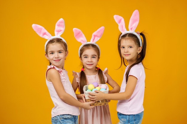 Ragazze del bambino che tengono cesto con uova dipinte