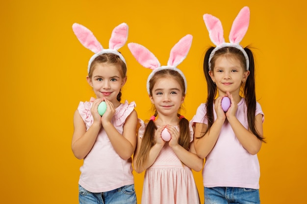 Ragazze del bambino che tengono le uova di Pasqua dipinte