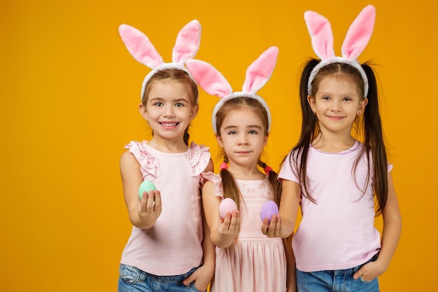 Ragazze del bambino che tengono le uova di Pasqua dipinte