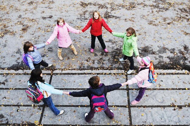 ragazze di scuola felici che corrono all'aperto in un soleggiato giorno d'autunno