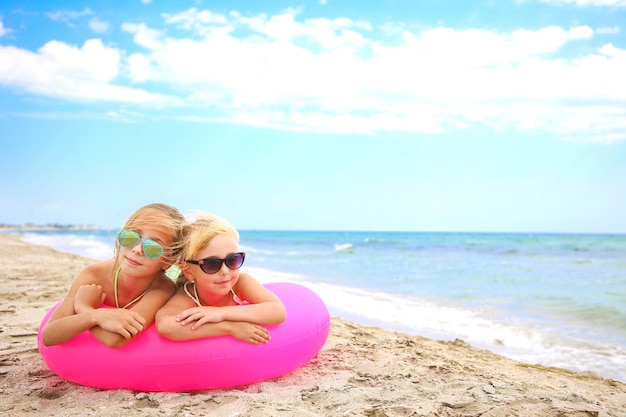 Ragazze felici che si trovano sul cerchio gonfiabile rosa.