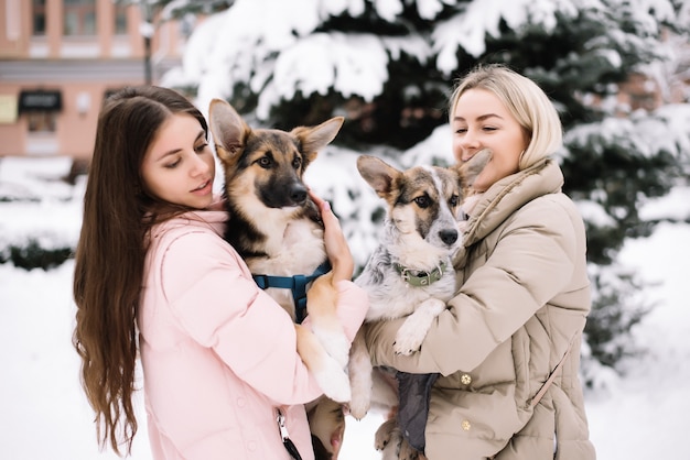 Ragazze felici che tengono i cani adorabili in mani