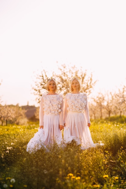 Ragazze gemelle che allungano le mani verso il cielo