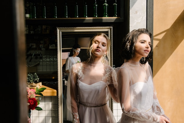 Ragazze in abiti da sposa bianchi sono in posa