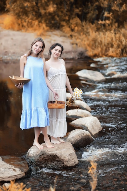 Ragazze in abiti in autunno sul fiume