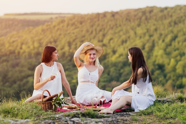 ragazze sedute su una coperta al picnic estivo