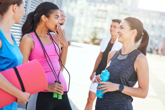 Ragazze sorridenti che parlano per strada dopo il fitness