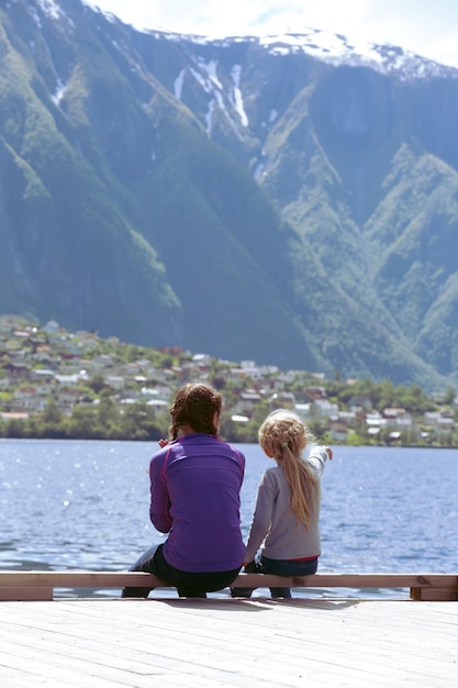 Ragazze sulla riva e ammira il bellissimo paesaggio norvegese sul fiordo e sulle montagne