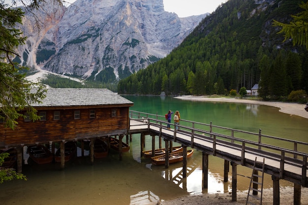 Ragazze zaino in spalla in piedi su un molo e guardando il lago di Braies, Dolomiti Italia