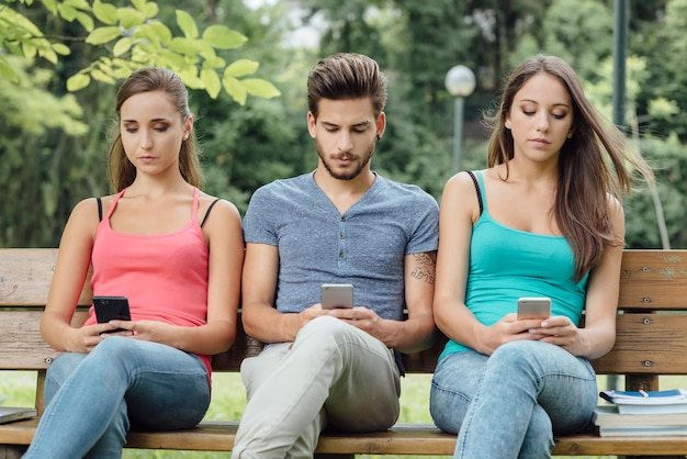 Ragazzi al parco che utilizzano smartphone