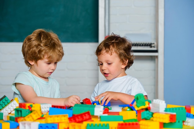 Ragazzi alunni della scuola elementare. I bambini piccoli giocano con blocchi, treni e automobili. Giocattoli educativi per bambini in età prescolare e materna.