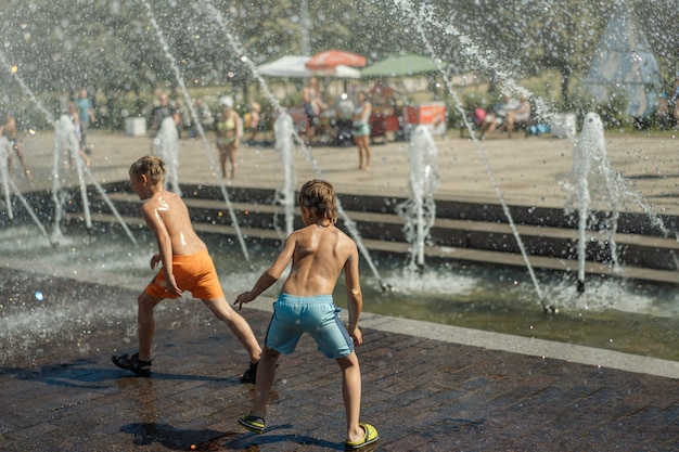 Ragazzi che corrono e giocano nella fontana della città in una calda giornata estiva saintpetersburg russia