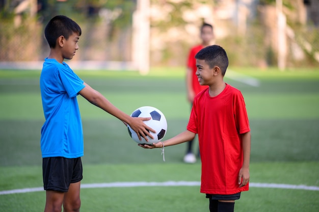 Ragazzi che giocano a calcio sul campo di pratica del calcio