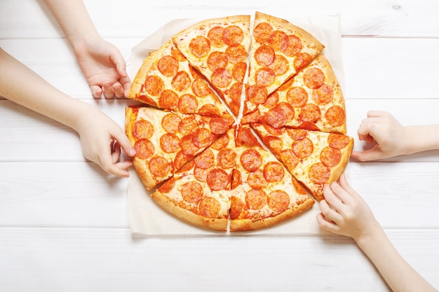 Ragazzi con una fetta di pizza.