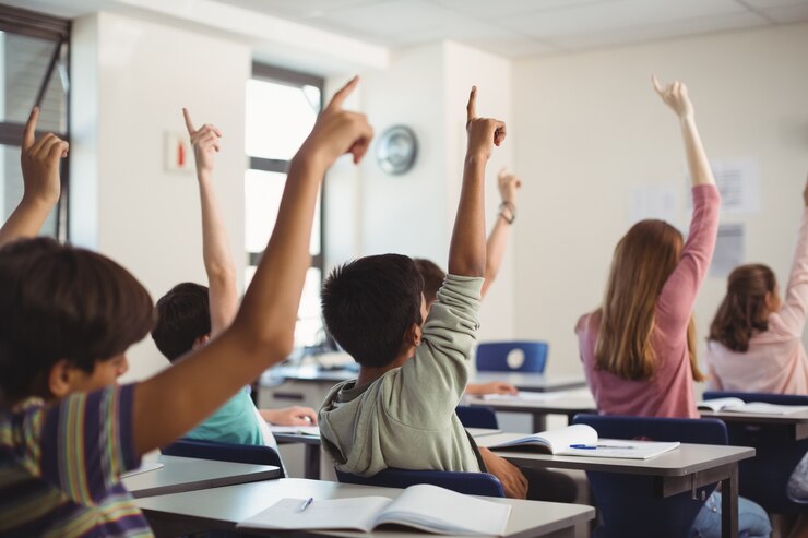 Foto ragazzi delle scuole alzando la mano in aula