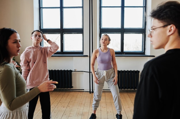 Ragazzi e ragazze adolescenti in abbigliamento sportivo che si rompono dopo un duro allenamento in studio