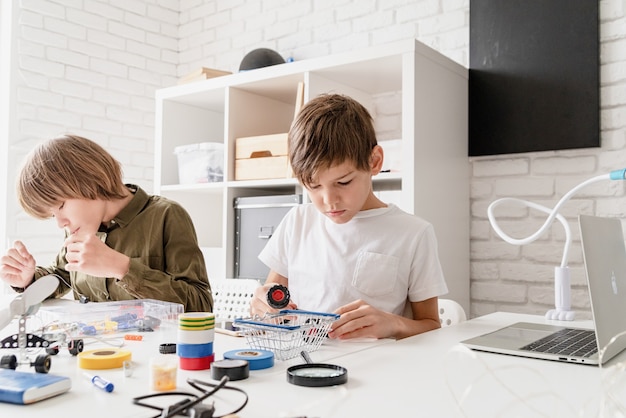 Ragazzi giovani e divertirsi costruendo insieme auto robot in officina