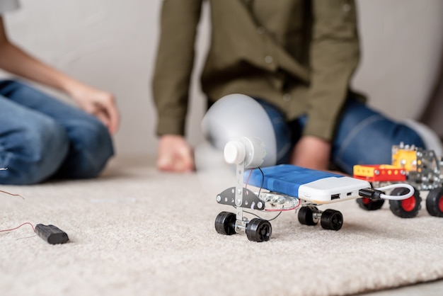 Ragazzi giovani e divertirsi costruendo insieme auto robot in officina