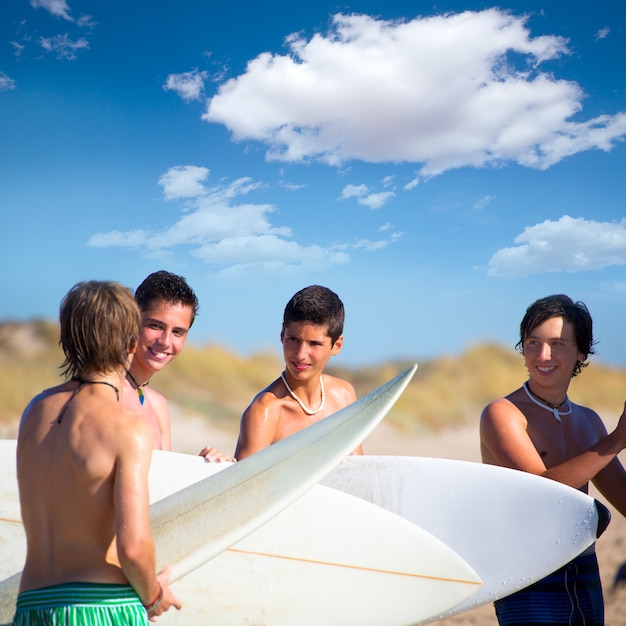 Ragazzi teenager del surfista che parlano sulla riva della spiaggia