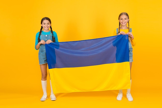 Ragazzi ucraini. Ragazze con bandiera blu e gialla. Educazione patriottica. Felice giorno dell'indipendenza. I bambini tengono la bandiera ucraina. Patriottismo rispetto e amore per la patria. Concetto di identità nazionale.
