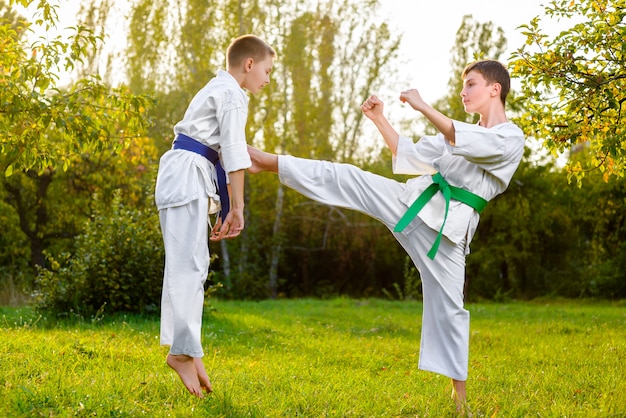 ragazzi vestiti di kimono facendo esercizi di karate