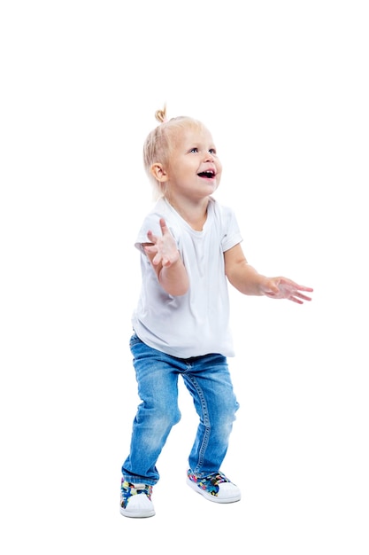 Ragazzina che ride con jeans e una maglietta bianca salta felice Felicità positiva e gioia Isolata su sfondo bianco Verticale a tutta altezza Spazio per il testo