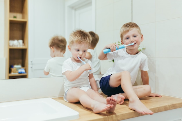 Ragazzini bambini che lavano i denti in bagno, due fratelli