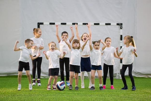 Ragazzini che giocano a calcio al chiuso squadra di calcio per bambini felici