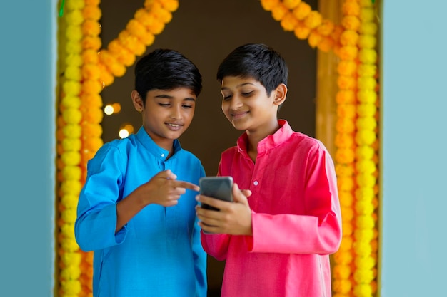 Ragazzini indiani che utilizzano smartphone e si godono il festival di diwali.