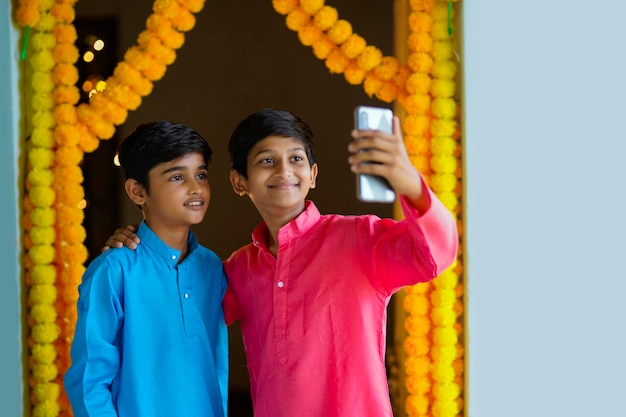 Ragazzini indiani che utilizzano smartphone e si godono il festival di diwali.