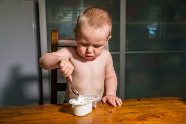 Ragazzino adorabile che mangia la ricotta con un cucchiaio