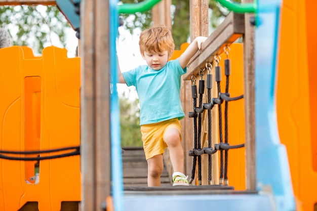 Ragazzino allegro nel parco giochi