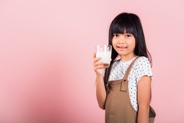 Ragazzino asiatico 10 anni sorriso tenere bicchiere di latte bere latte bianco