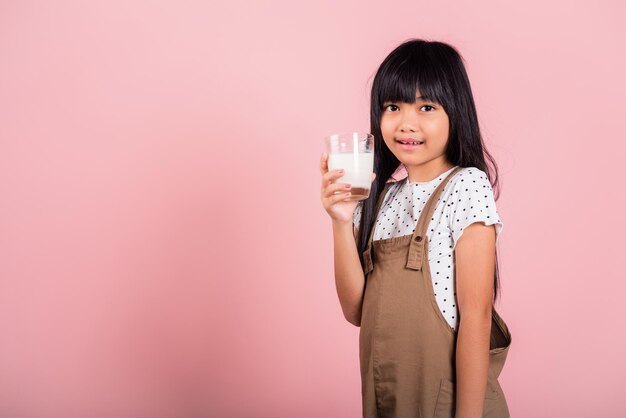 Ragazzino asiatico 10 anni sorriso tenere bicchiere di latte bere latte bianco