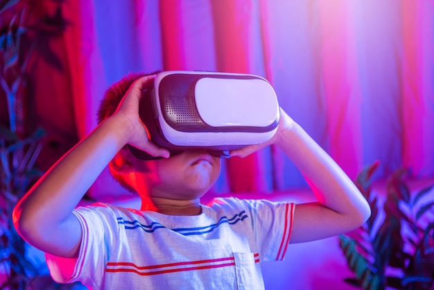 Ragazzino asiatico che indossa occhiali per realtà virtuale vivendo la realtà