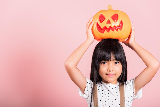 Ragazzino asiatico di 10 anni che tiene la zucca di Halloween scolpita