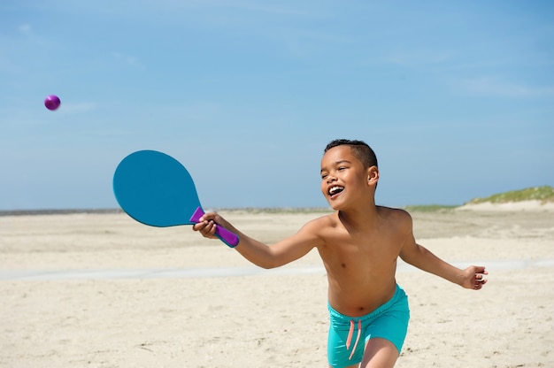 Ragazzino attivo che gioca in spiaggia