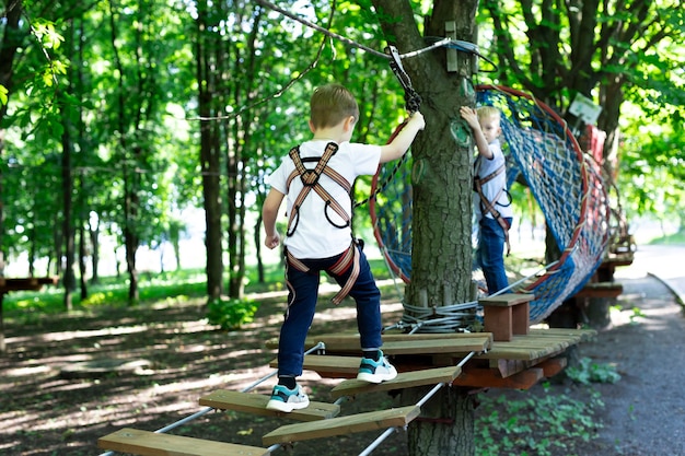 Ragazzino attivo che si arrampica su una corda verso il parco divertimenti