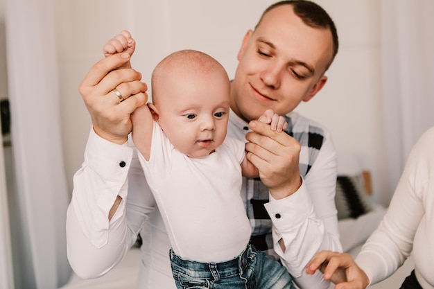 Ragazzino bambino carino con gli occhi sporgenti che gioca con i genitori, in piedi in posa come un supereroe