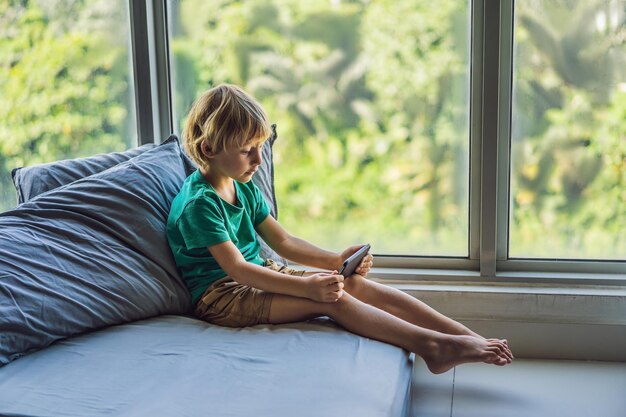 Ragazzino biondo che gioca sullo smartphone