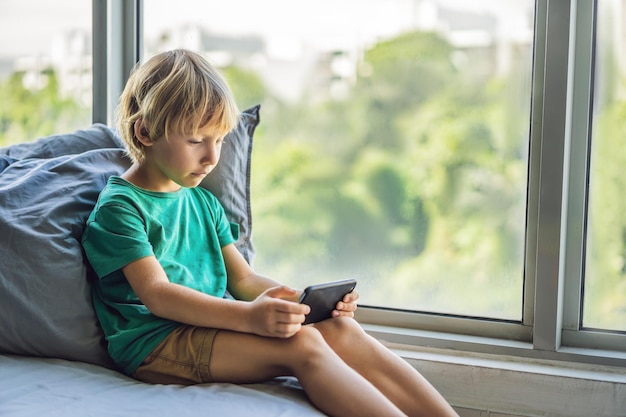 Ragazzino biondo che gioca sullo smartphone