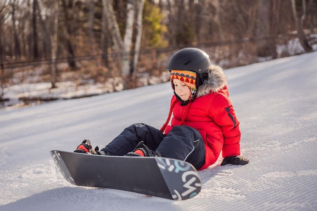 Ragazzino carino attività di snowboard per bambini in inverno stile di vita sport invernali per bambini