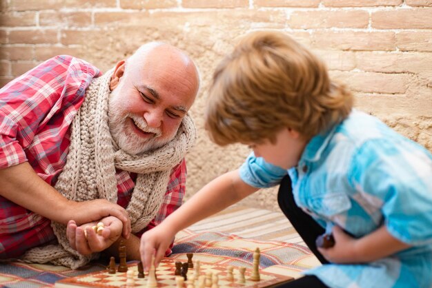 Ragazzino carino che gioca a scacchi infanzia ragazzino carino che gioca a scacchi generazioni bel nonno a