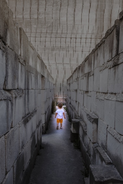 Ragazzino caucasico che cammina con la prospettiva del labirinto. Immagine concettuale per situazione pericolosa durante l'infanzia.