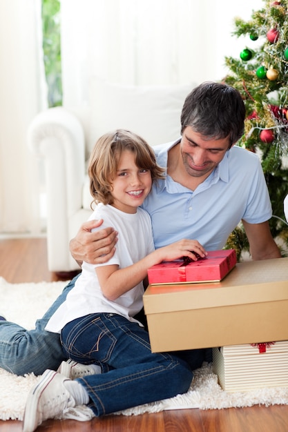 Ragazzino che apre i regali di Natale con suo padre