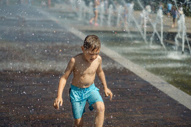 ragazzino che corre nella fontana a spruzzi di san pietroburgo in russia