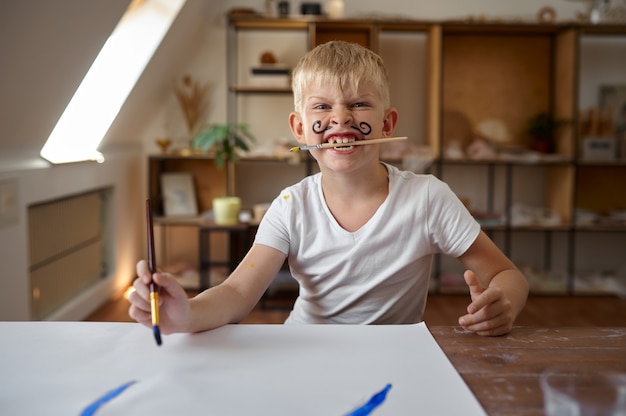 Ragazzino che disegna con la tempera sul viso