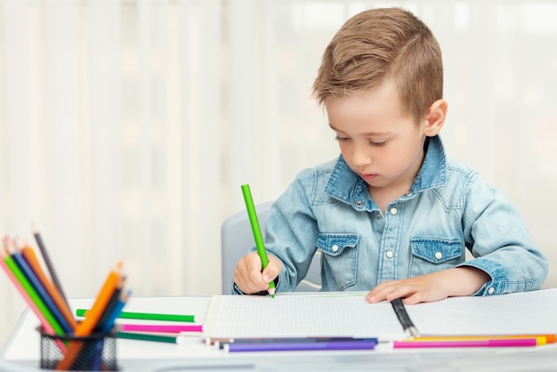 Ragazzino che fa i compiti di scrittura e pittura