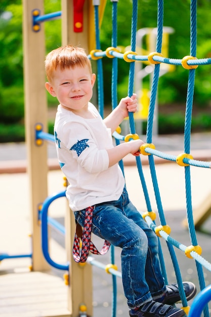 Ragazzino che gioca nel parco giochi.